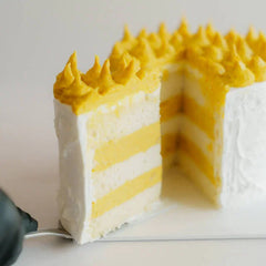 Layered durian cake with creamy yellow and white frosting, ideal for flower delivery gifts