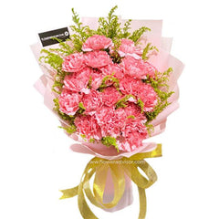 Pink carnation bouquet with greenery, wrapped in pastel paper and gold ribbon for flower delivery