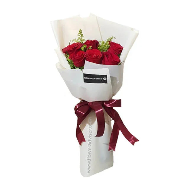 Bouquet of six red roses with greenery in white wrapping, perfect for flower delivery