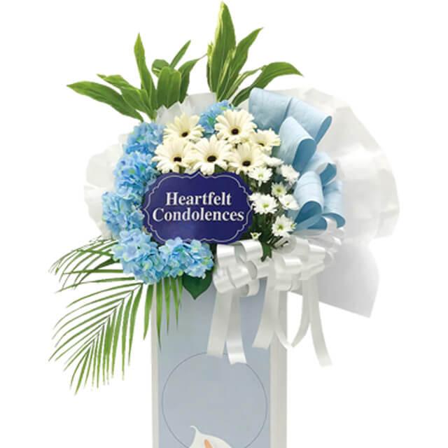 Condolence flower stand with blue hydrangeas and white daisies for delivery in Singapore