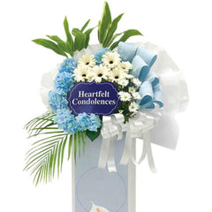 Condolence flower stand with blue hydrangeas and white daisies for delivery in Singapore