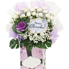Condolence flower stand with fresh white roses, purple accents, and same-day delivery