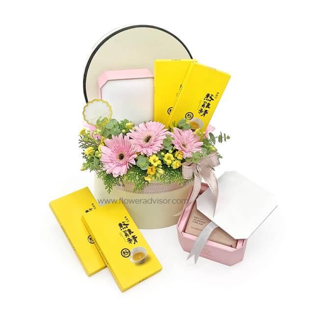 Fresh flower hamper with pink gerbera daisies, yellow blooms and gift boxes for delivery