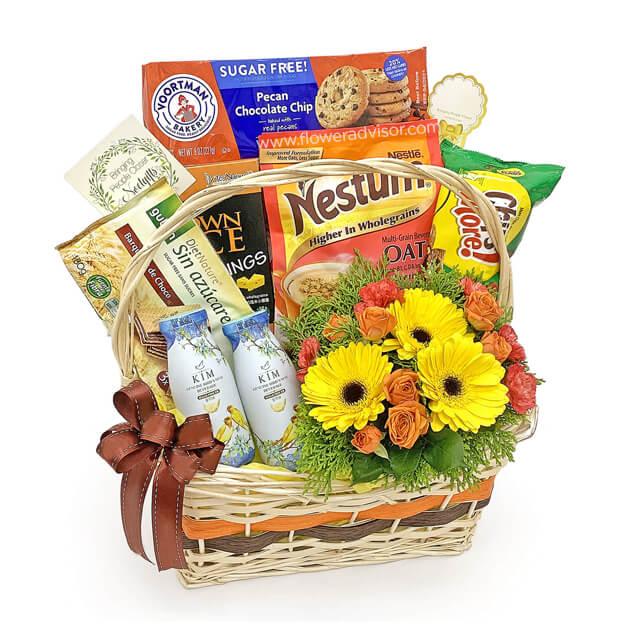 Flower delivery basket with yellow and orange flowers, gourmet snacks, and a brown ribbon.