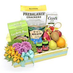 Flower delivery hamper with fresh roses, orchids, assorted fruits, and gourmet snacks