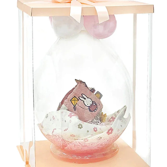 Floral-themed gift hamper with plush toy and flower blanket in clear box, ideal for flower delivery.