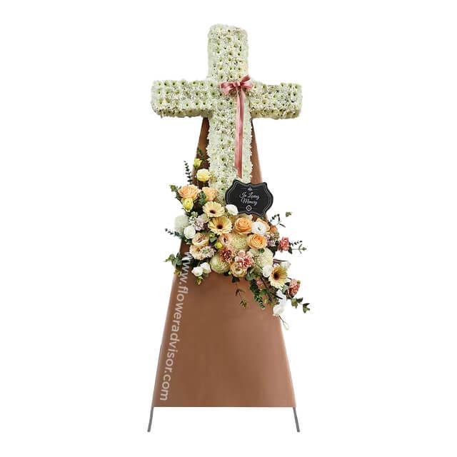 Flower delivery of white floral cross with peach and yellow bouquet for condolences