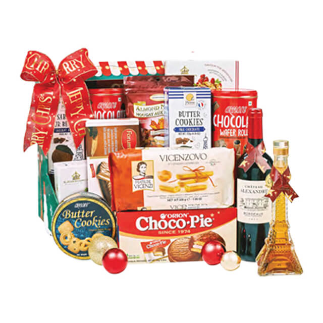 Gift hamper with snacks, cookies, wine and Eiffel Tower-shaped bottle, festive basket for flower delivery