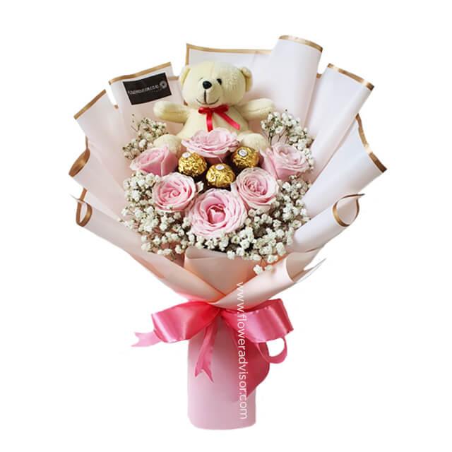 Flower delivery of pink rose bouquet with teddy bear, chocolates, and baby's breath flowers