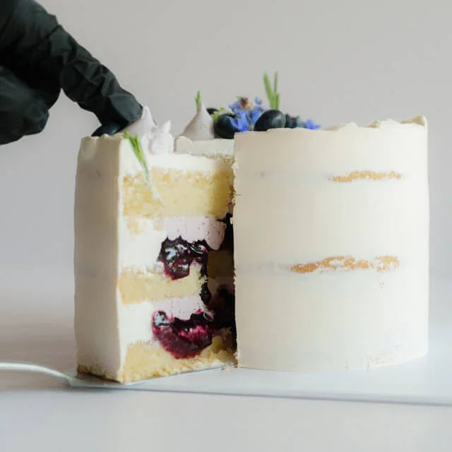 Elegant floral cake with blueberries and fresh flowers, perfect for flower delivery occasions