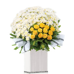 Flower delivery arrangement with yellow roses and white chrysanthemums in a white stand