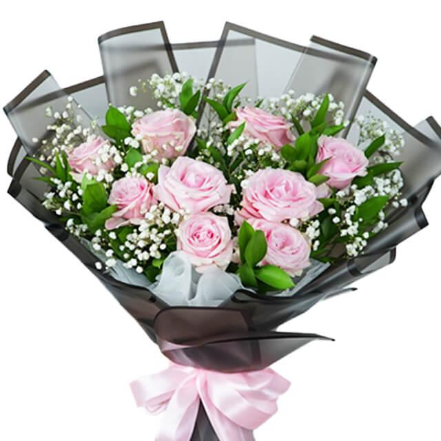 Pink rose bouquet with baby’s breath, wrapped in black for flower delivery
