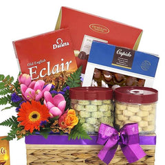 Flower delivery gift basket with fresh flowers, cookies, chocolates, and gourmet treats