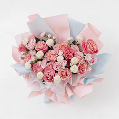 Pink rose bouquet with white blooms in pastel wrapping for flower delivery
