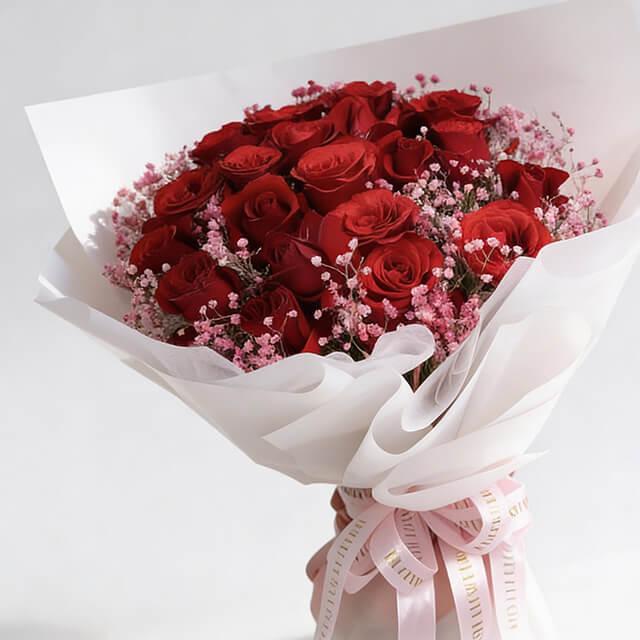 Red rose bouquet with pink baby's breath in white wrapping, ideal for flower delivery in Singapore
