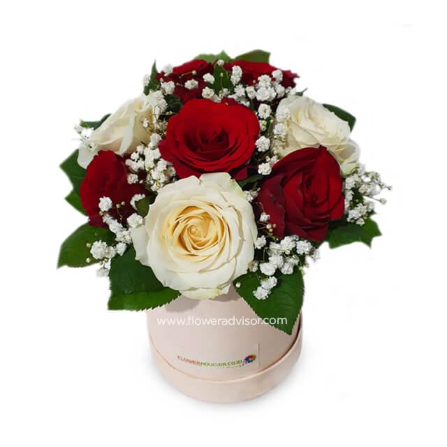 Elegant flower delivery arrangement with red and white roses in a gift box