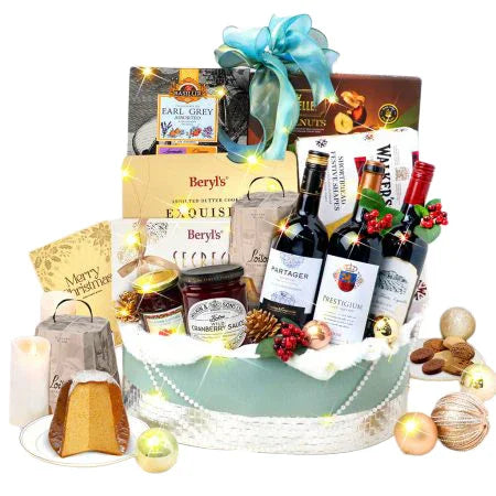 Festive flower delivery gift basket with red wine, chocolates, snacks, and ornaments