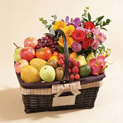 fruit basket with fresh mixed flowers and assorted fruits on a light background