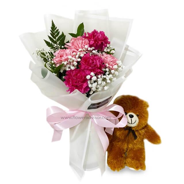 Flower delivery of a pink carnation bouquet with baby's breath and a plush teddy bear
