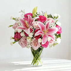 Elegant pink lily and rose bouquet in glass vase for flower delivery
