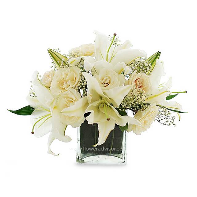 White lily and rose bouquet in glass vase for flower delivery