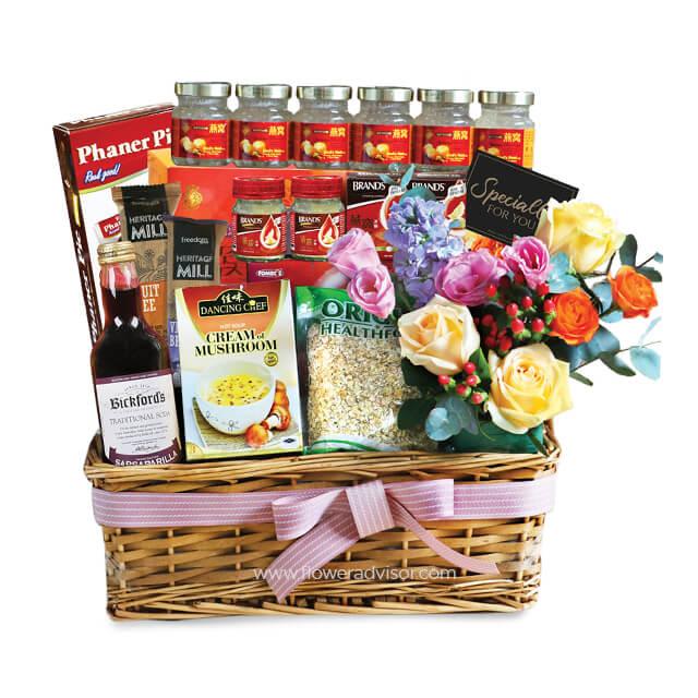 Flower delivery hamper with fresh roses, assorted health foods, and gourmet gifts in a basket