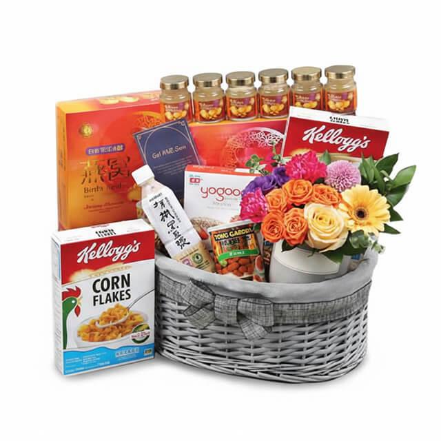 Flower delivery hamper with fresh bouquet, cereal boxes, health supplements, and snacks in a basket