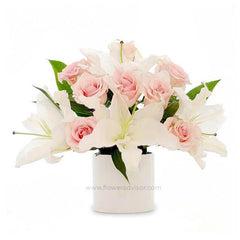 Elegant flower delivery arrangement with pink roses and white lilies in a white vase