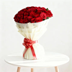 Elegant bouquet of red roses in white wrapping with red ribbon, perfect for flower delivery