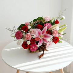 Fresh flower bouquet with lilies, roses, and carnations in basket for delivery