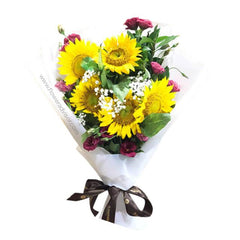 Bright sunflower bouquet with pink roses in white wrapping for flower delivery in Singapore