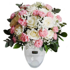 Pastel flower bouquet with pink carnations and white roses in a vase for delivery