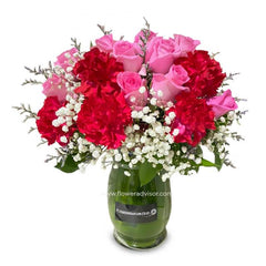 Pink rose and red carnation table arrangement in vase for flower delivery