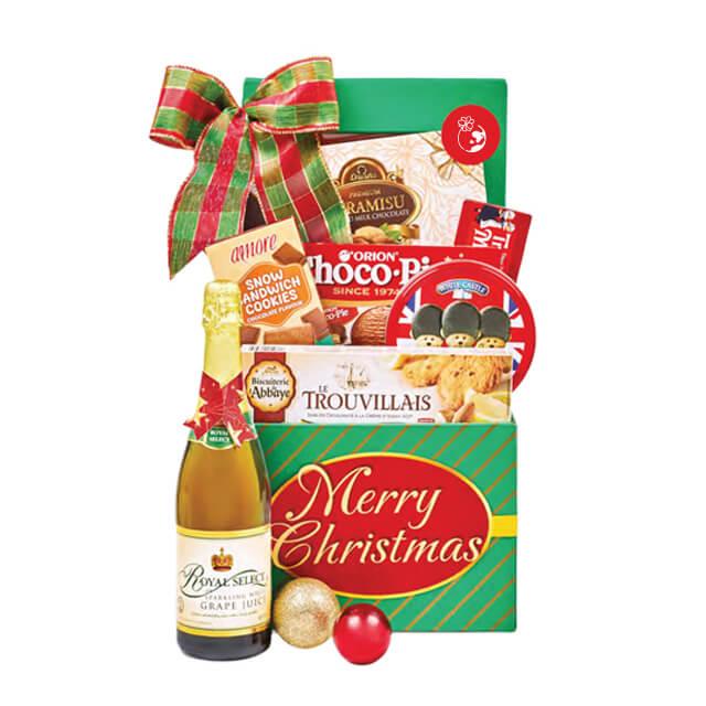 Christmas hamper with sparkling juice, cookies, and holiday treats for festive flower delivery