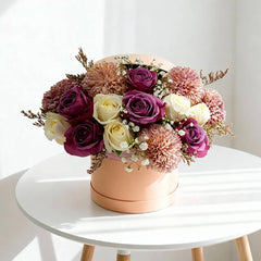 Elegant flower arrangement with purple and cream roses in a round box for flower delivery