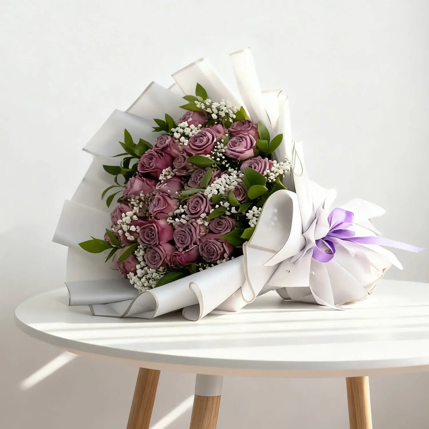 Elegant mauve rose bouquet with greenery, white filler flowers and purple ribbon for flower delivery