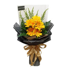 Hand bouquet of five yellow gerberas with greenery, wrapped for flower delivery