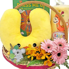 Flower delivery basket with fresh pink and yellow flowers, soft toy, and baby gift items