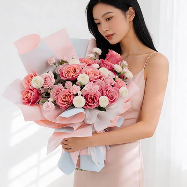 Woman holding large pink rose bouquet for flower delivery, wrapped in pastel paper
