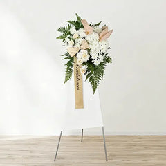 White condolence flower stand with greenery for sympathy flower delivery