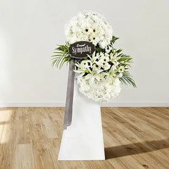 White condolence flower stand with lilies and chrysanthemums for sympathy flower delivery