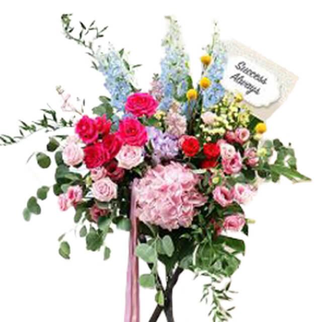 Grand opening flower stand with pink, red, and blue blooms for flower delivery in Singapore