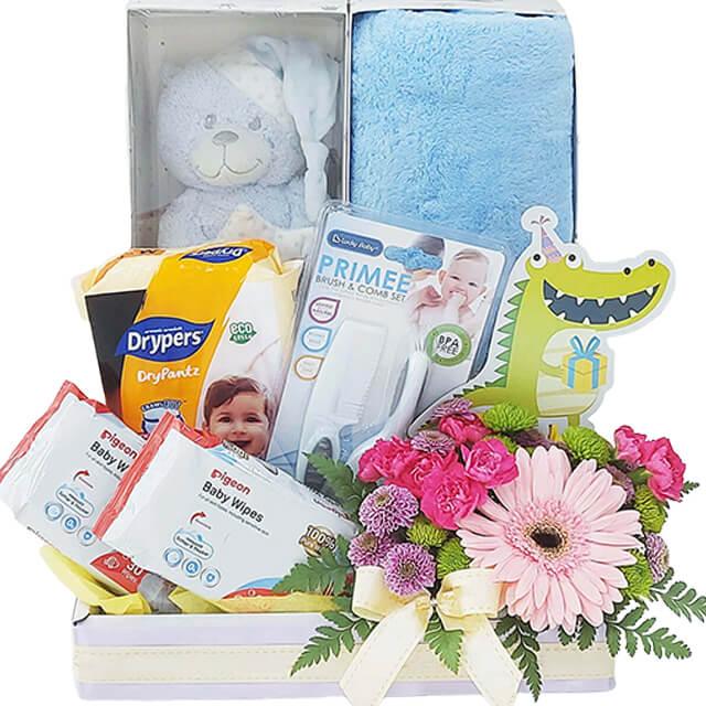 Baby gift hamper with pink flowers, plush toy, baby wipes, and diapers for flower delivery
