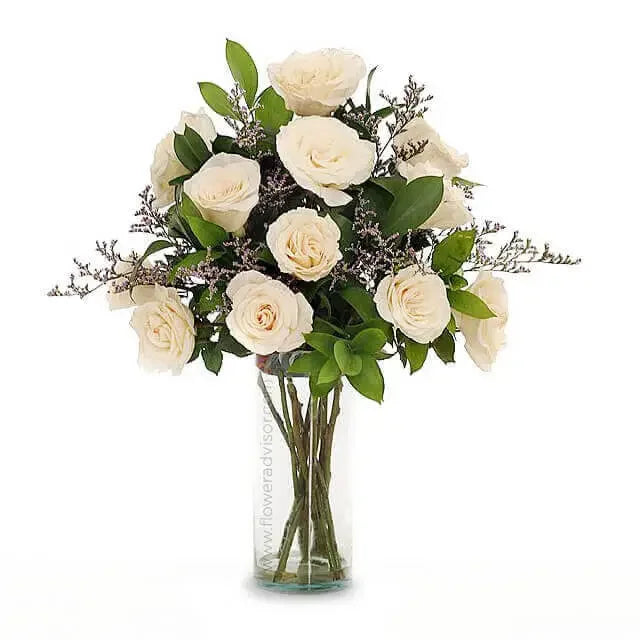 White rose bouquet in vase for flower delivery, accented with greenery and filler flowers
