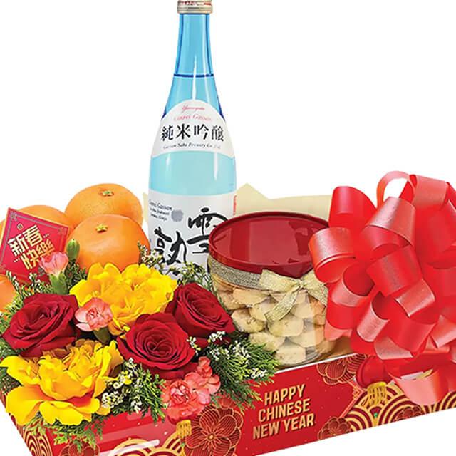 Chinese New Year flower hamper with red roses, yellow blooms, oranges, snacks, and wine for delivery