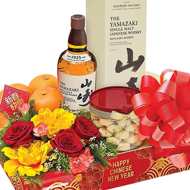 Chinese New Year flower hamper with fresh blooms, oranges, snacks, and whisky for delivery