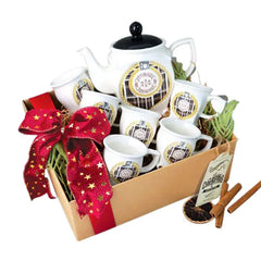 Elegant tea set with festive bow arranged in a gift box for flower delivery gifting