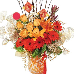 Vibrant orange and yellow fresh flower arrangement in a decorative vase for flower delivery