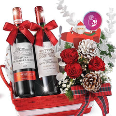 Festive flower delivery basket with red roses, pine cones, and two wine bottles.