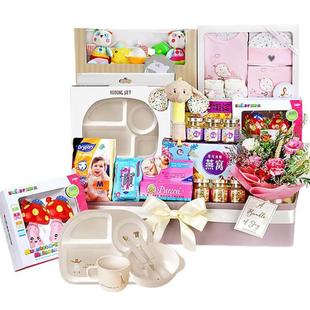 Newborn gift hamper with baby essentials, bird's nest, and pink flower bouquet for delivery